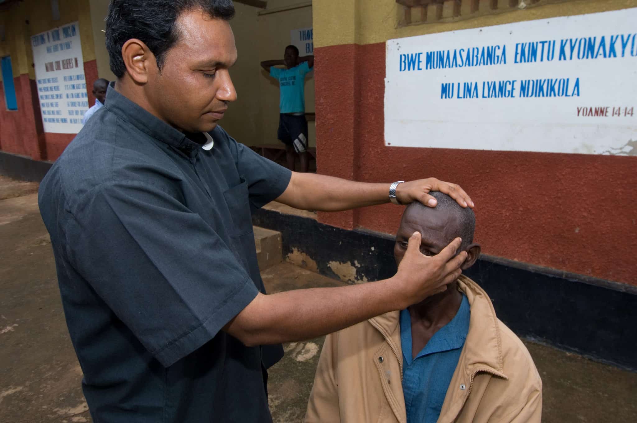 Fr. Matthew Mundackan, who trained in a wide range of holistic healing practices in his native India before coming to Uganda in 1997, opened the St. Clarets Holistic Healing Center one year after his arrival. Here, he performs accu-pressure on a man with high blood pressure.